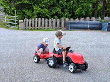 Junges Paar mit Trettraktor